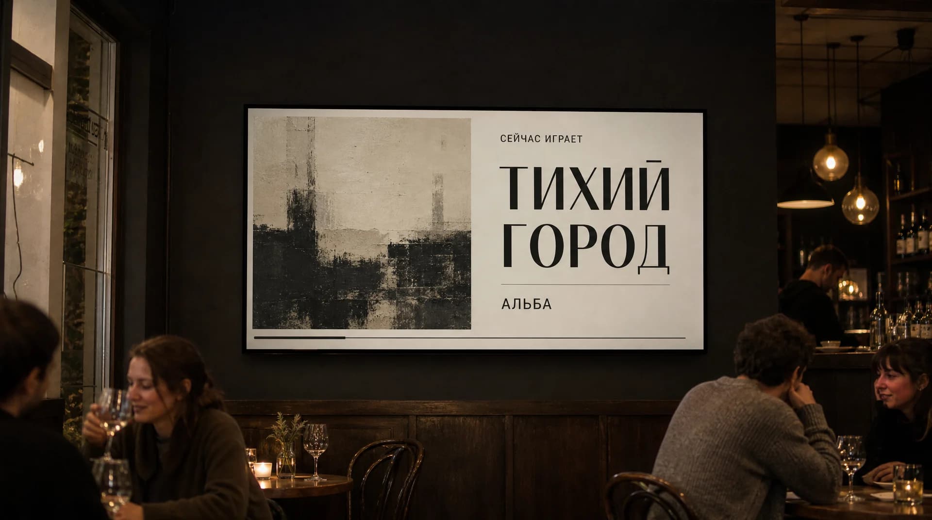 Экран в зале бара показывает, что сейчас играет: обложка альбома, название трека и исполнитель, гости за столиками