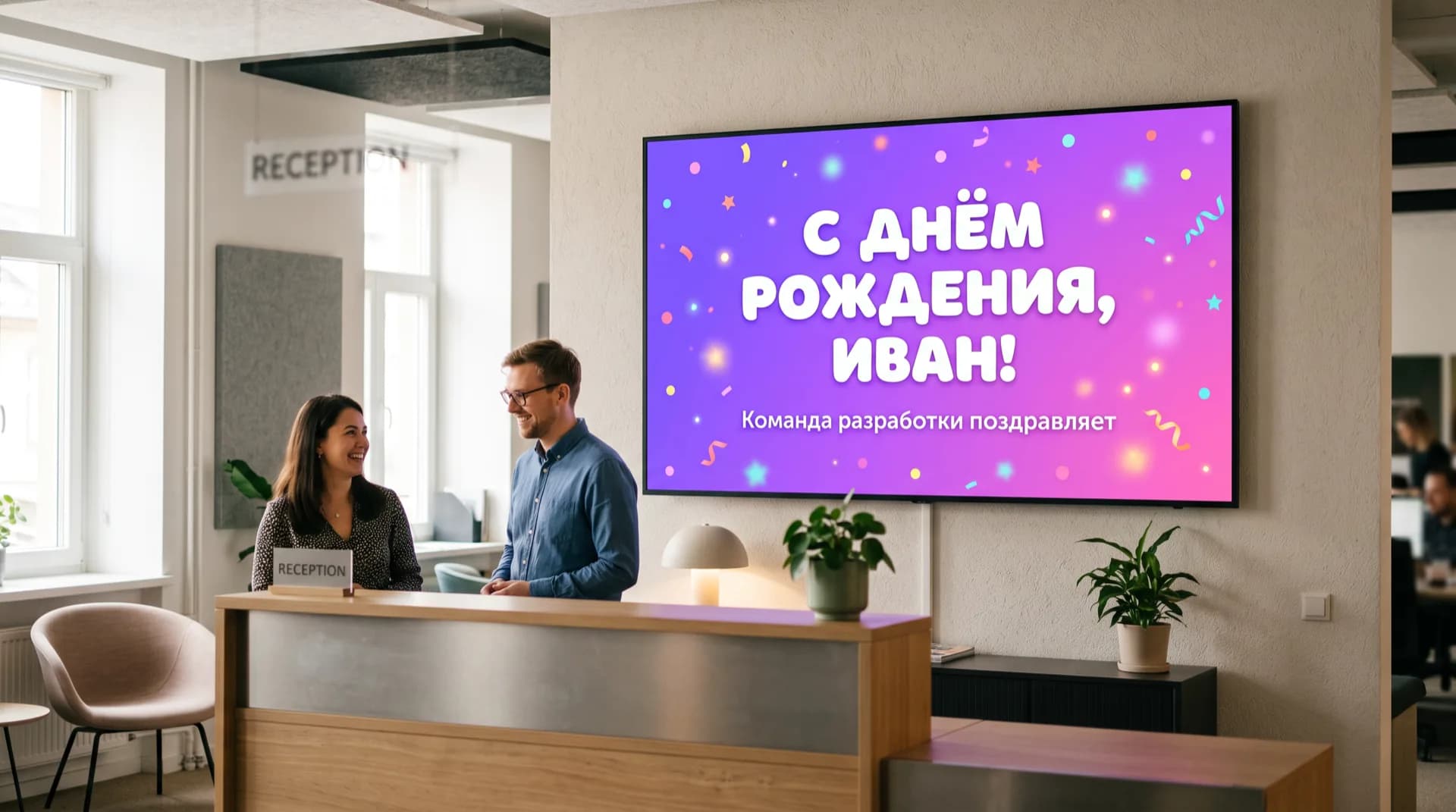 Экран на ресепшн офиса показывает праздничный слайд «С днём рождения, Иван!» с конфетти, рядом разговаривают двое сотрудников